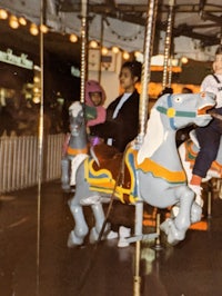 a child is riding a carousel