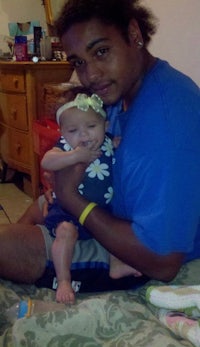 a man holding a baby on a bed