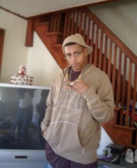 a man in a hat standing in front of a tv