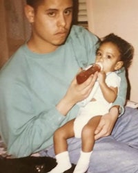 a man holding a baby while holding a bottle