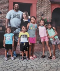 a family posing for a picture in front of a brick building