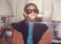 a young boy wearing sunglasses and a jacket