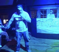 a man on stage with a microphone in front of a crowd