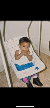 a baby sitting in a baby swing