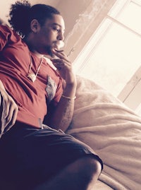 a man sitting on a couch smoking a cigarette