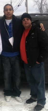 three men standing in front of a car in the snow