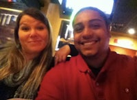 a man and woman posing for a photo at a bar