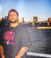 a man standing on a bridge with the brooklyn bridge in the background