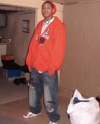 a man in an orange hoodie standing in a room