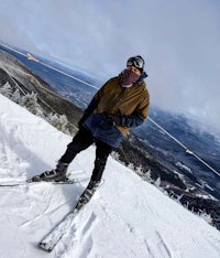 a man on skis standing on top of a mountain