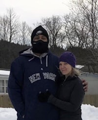 a man and woman posing for a photo in the snow